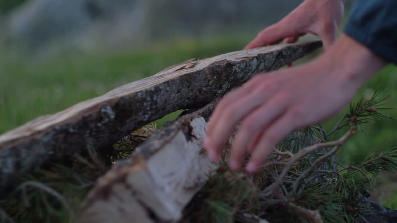 프랑스 시골 자연에서 캠프 불을 만들기 위해 나무를 준비하는 젊은 남자의 클로즈업