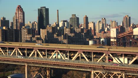 traffic moves across the queensboro bridge with the new york skyline background