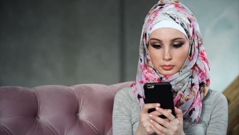 woman wearing hijab using smartphone