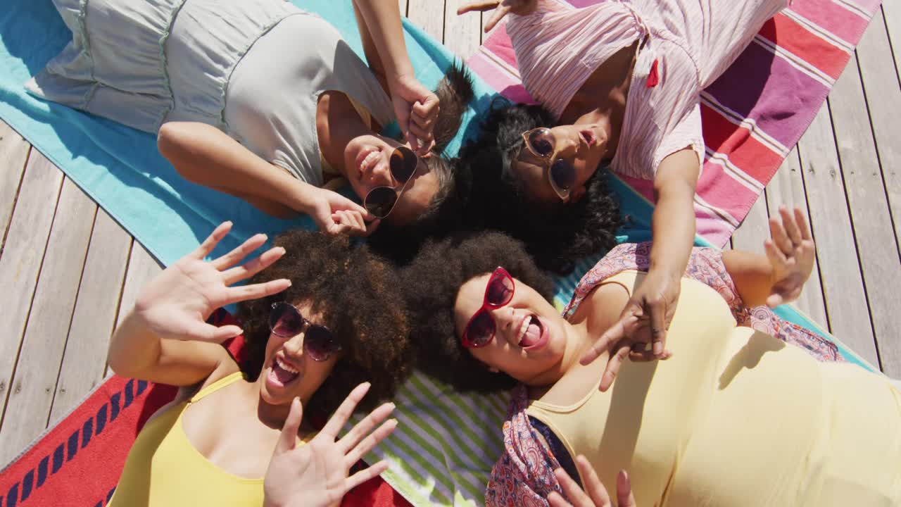Portrait of happy diverse female friends smiling at swimming pool party
