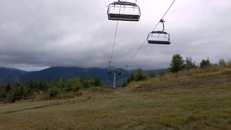 Low-angle-shot-of-empty-elevator-cableway-for-people-transportation-along-the-mountain-range-on-a-cloudy-day