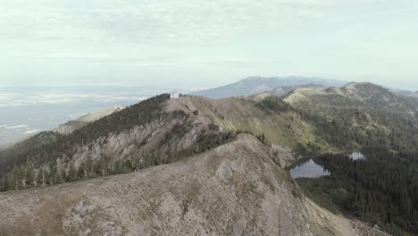 man hikes alone along a beautiful ridge over looking a far off valley