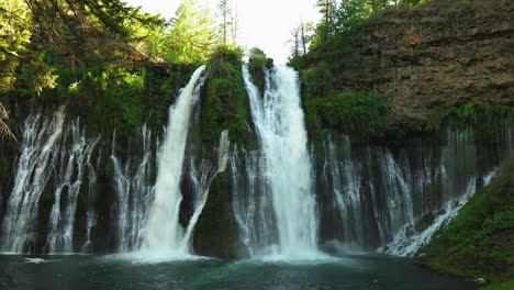 Panorama-of-Burney-Falls,-forest-waterfall-in-California,-with-water-falling-down-a-mossy-cliff