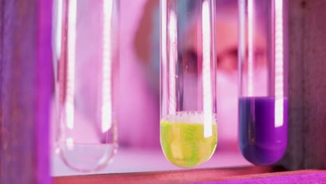 scientist in lab carefully drips the solution into glass tubes experimenting a chemical reaction test for coronavirus