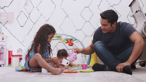 Young-girl-playing-tea-party-with-dad,-dad-pouring-tea-and-baby-brother-beside-them,-low-angle