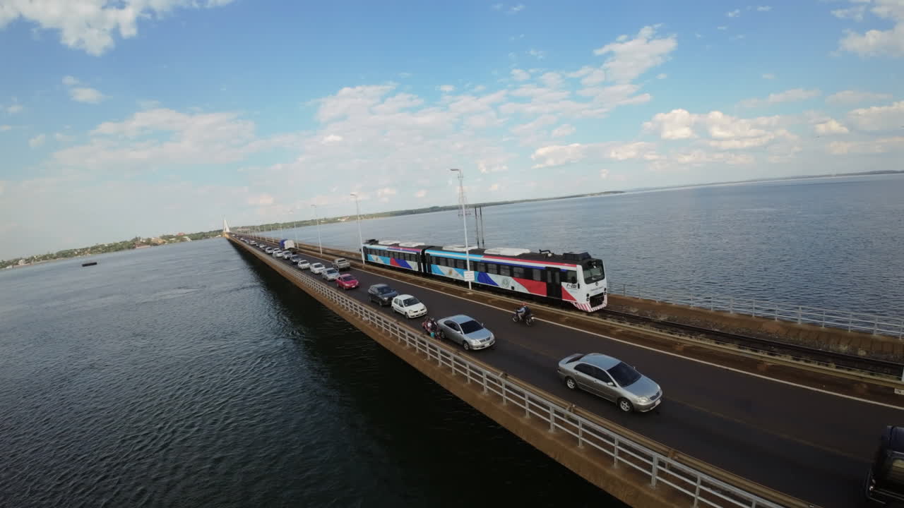 Binational train crossing bridge over Paraná River, border Argentina and Paraguay, aerial view