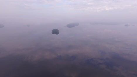 amazing drone footage of a big lake in finland with small islands by misty dawn