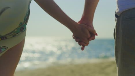 couple holding hands on the beach