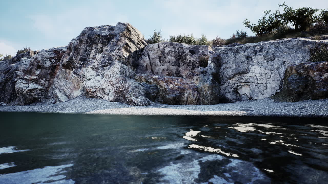 una orilla rocosa con un río tranquilo