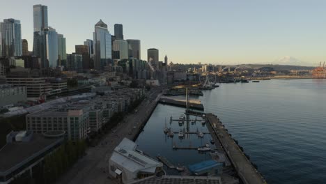 Drohne-Fliegt-Bei-Tageslicht-In-Richtung-Der-Skyline-Von-Seattle-Mit-Dem-Berg-Regnerischer-Im-Hintergrund,-Sommerluftaufnahme