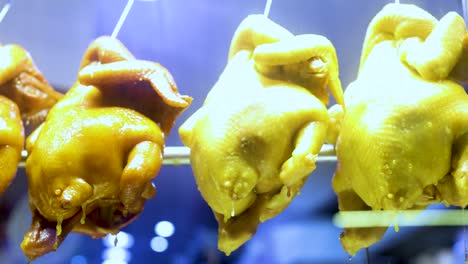 hanging roasted chickens and ducks in a shop