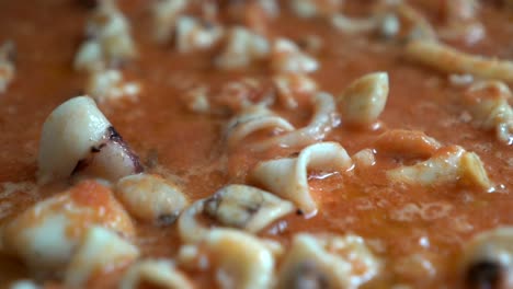 appetizing squid relying on tomato during the preparation of fideua seen