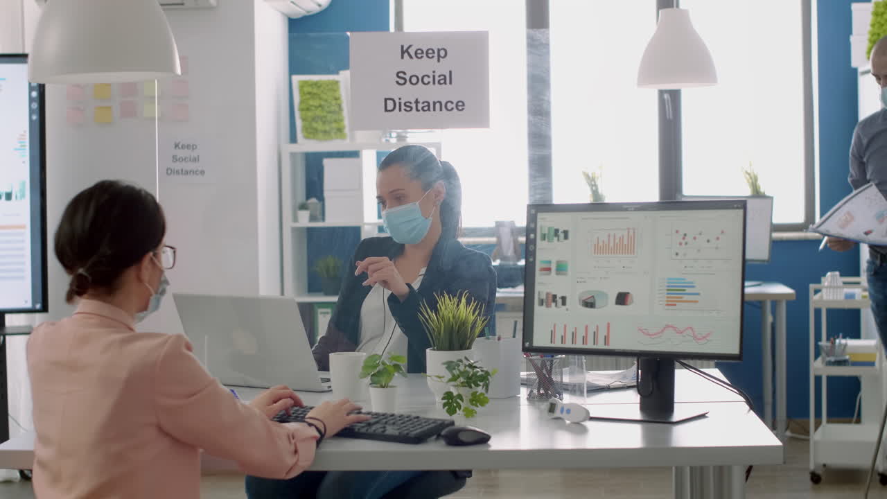 Team workers with protection face masks working in business office