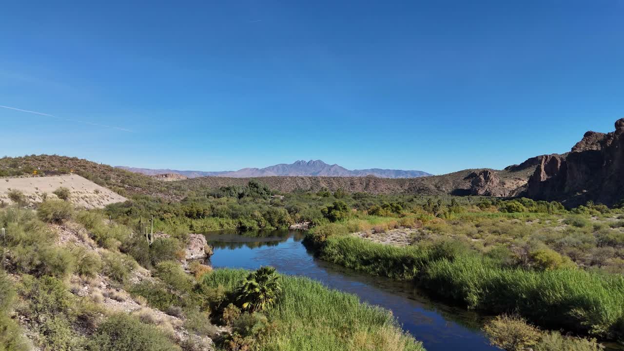 Drone che vola sopra un fiume circondato da montagne