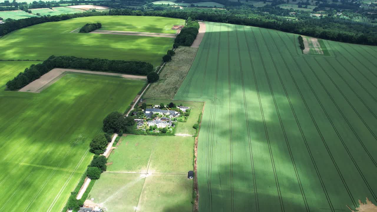 Green Fovant village agricultural farmland covered with cloud shadows in rural Wiltshire countryside