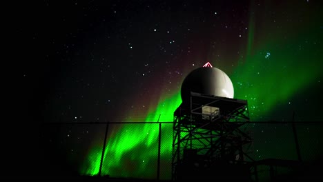 northern lights behind tower in arctic tundra