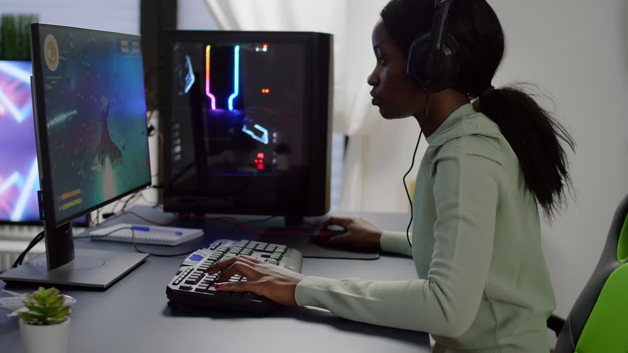 Glad sort gamer løfter hænderne og vinder en online rumskydespilskonkurrence.