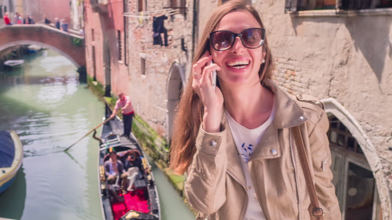 베네치아에서 전화로 이야기하는 행복한 여성