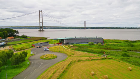 Experience-Humber-Bridge-through-aerial-drone-lens,-12th-largest-single-span,-gracefully-crossing-River-Humber,-connecting-Lincolnshire-and-Humberside,-with-bustling-traffic