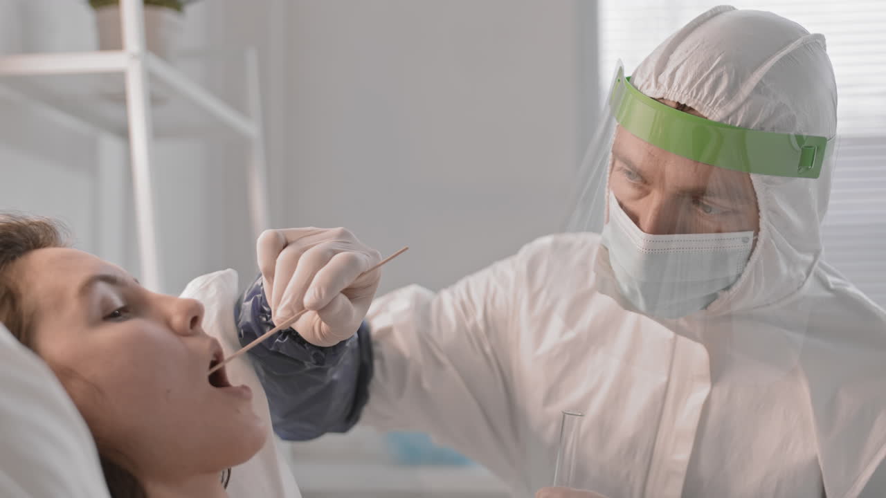 el médico toma una muestra de saliva del paciente