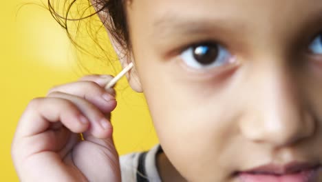 child cleaning ear with cotton swab