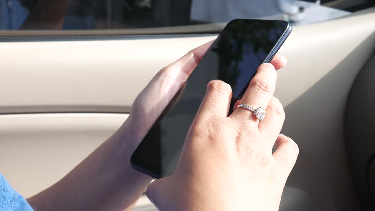 imágenes de primer plano de la mano de una mujer usando un teléfono móvil o un teléfono inteligente en un automóvil