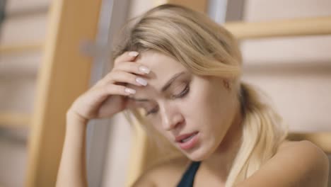 portrait of exhausted female instructor feeling sad in sport club.