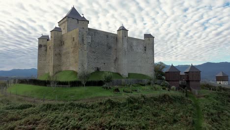 aerial view on mauvezin castle, a fortress with a medieval military architecture located in occitania, france (dolly forward)