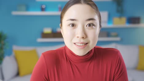 Asian-woman-looking-at-camera-and-surprised-by-news-on-laptop-screen.