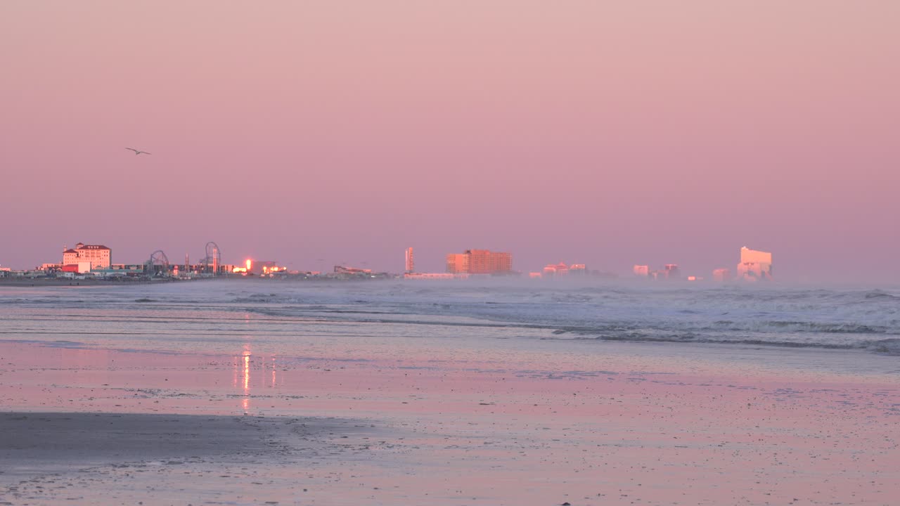 먼 배경의 뉴저지에 있는 바다와 대서양 도시의 전망을 감상할 수 있는 대서양 위로 자줏빛을 띤 분홍색 일몰 하늘 - 와이드 샷