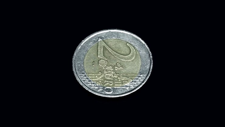 Moneta europea da due euro che ruota su sfondo nero. Macro. Primo piano