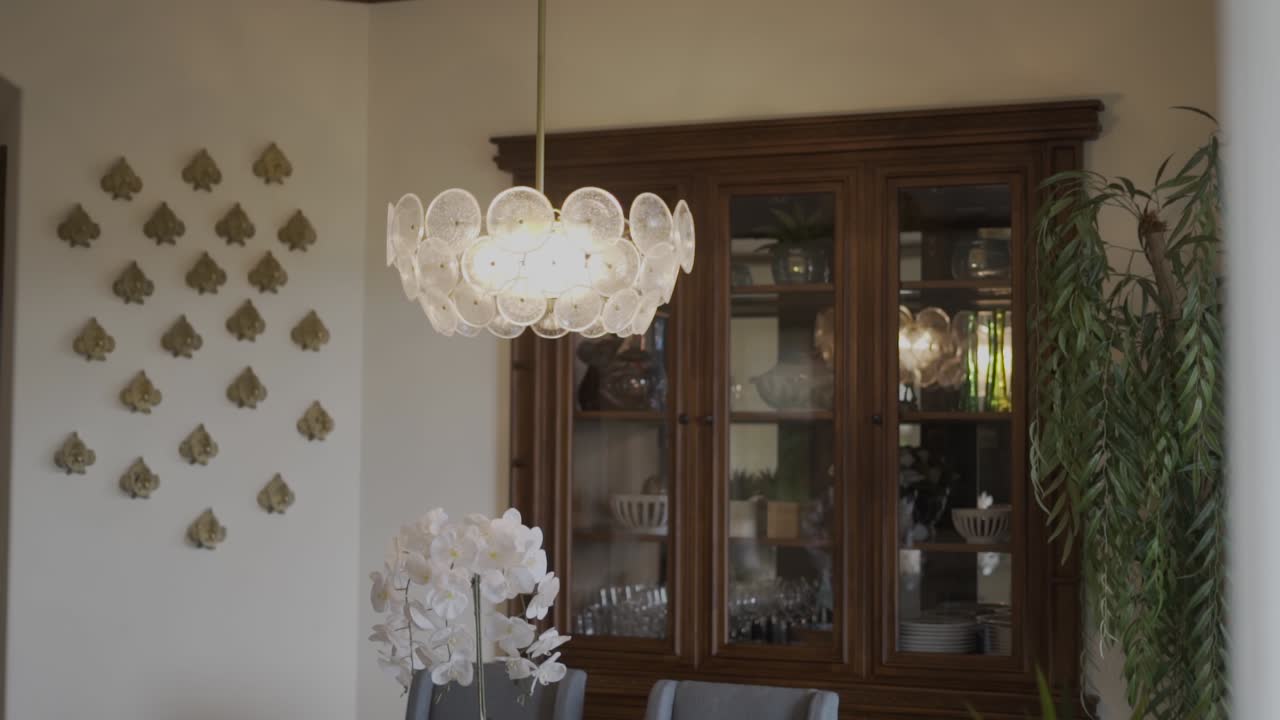 living room with wooden cabinet and fish head ornaments on the wall with lighted chandelier hanging on it