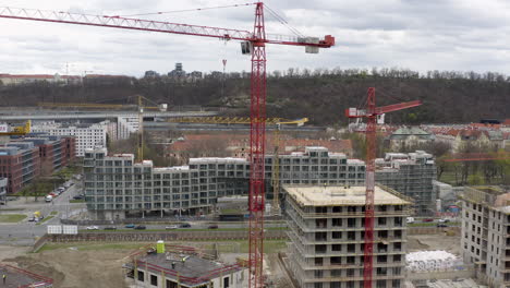 Red tower cranes at construction site in Prague, pedestal drone shot