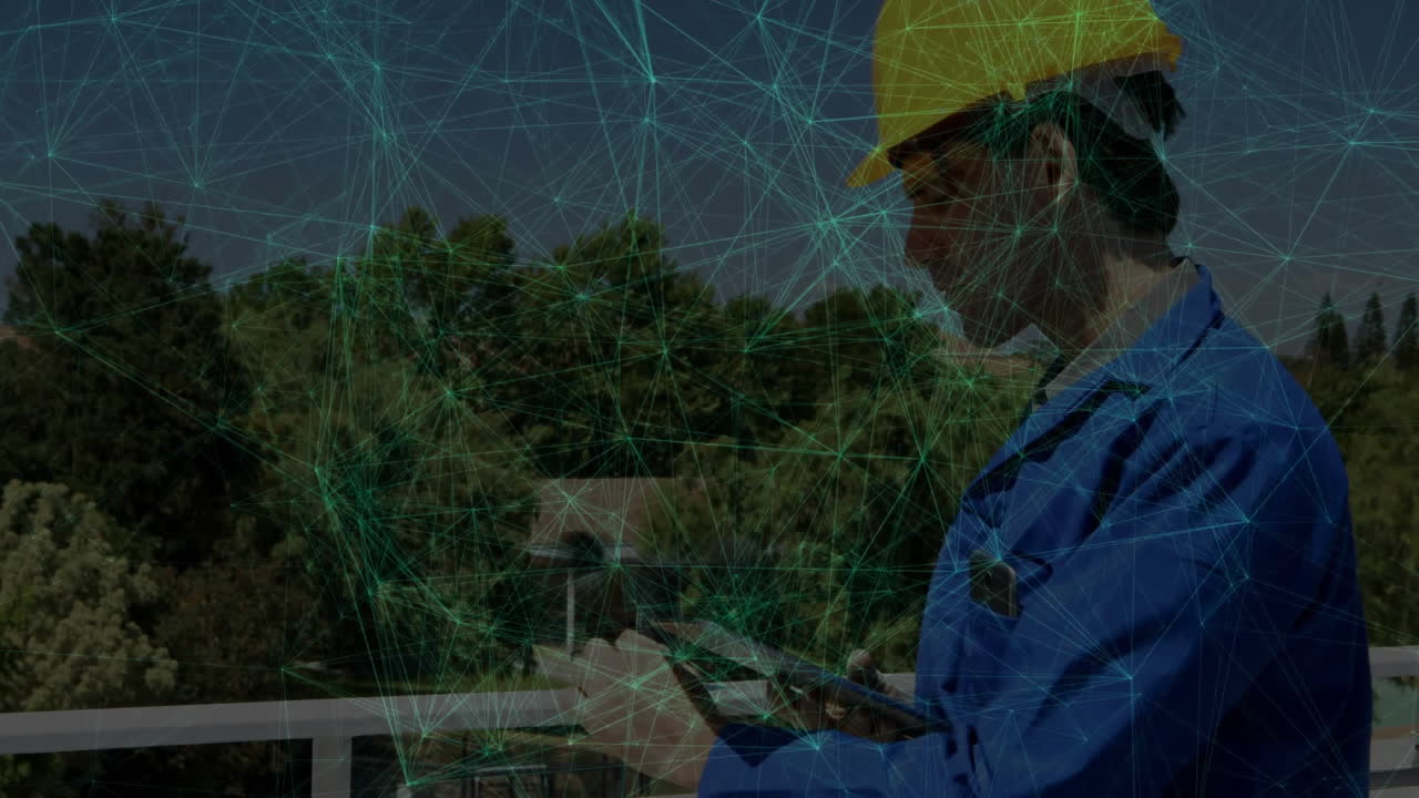 Construction worker tapping tablet on balcony overlooking forest, with animated data graphs