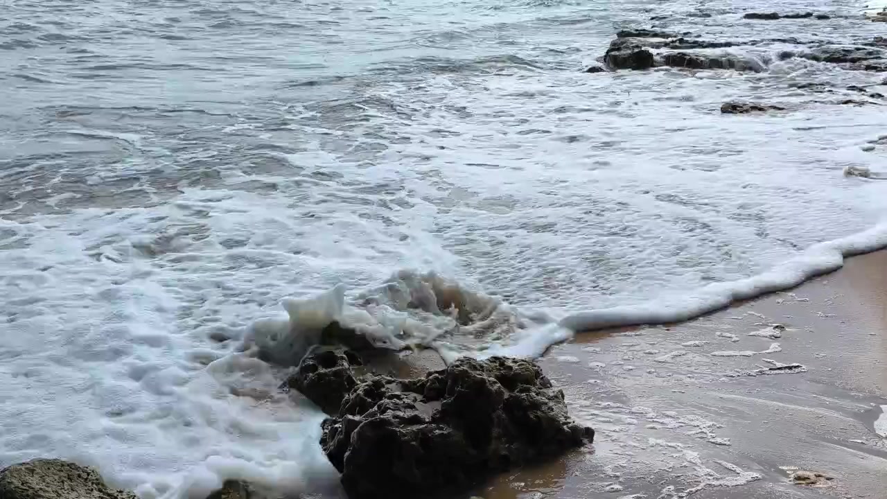 Le onde dell'oceano si schiantano contro la costa rocciosa