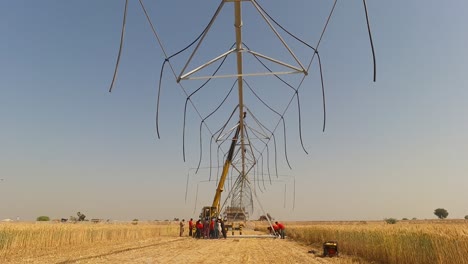 timelapse of group of men raising the pipes of center pivot irrigation system in pakistan