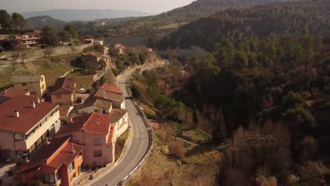 marganell town in barcelona with surrounding hills and winding roads, aerial view