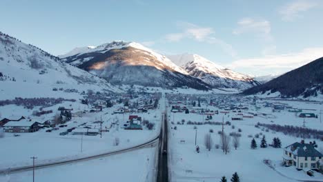 Rising-drone-shot-of-main-street-in-Silverton,-Colorado-with-a-car-driving