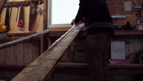 a man marking a piece of lumber in indre fosen, trondelag county, norway - static shot