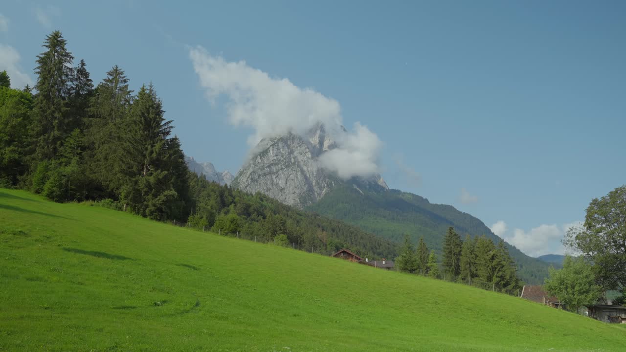 una pareja de excursionistas camina con un pico prominente en el fondo, los alpes alemanes