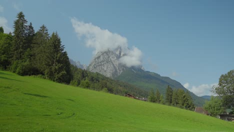 hiking couple walks by with prominent peak in the background, german alps