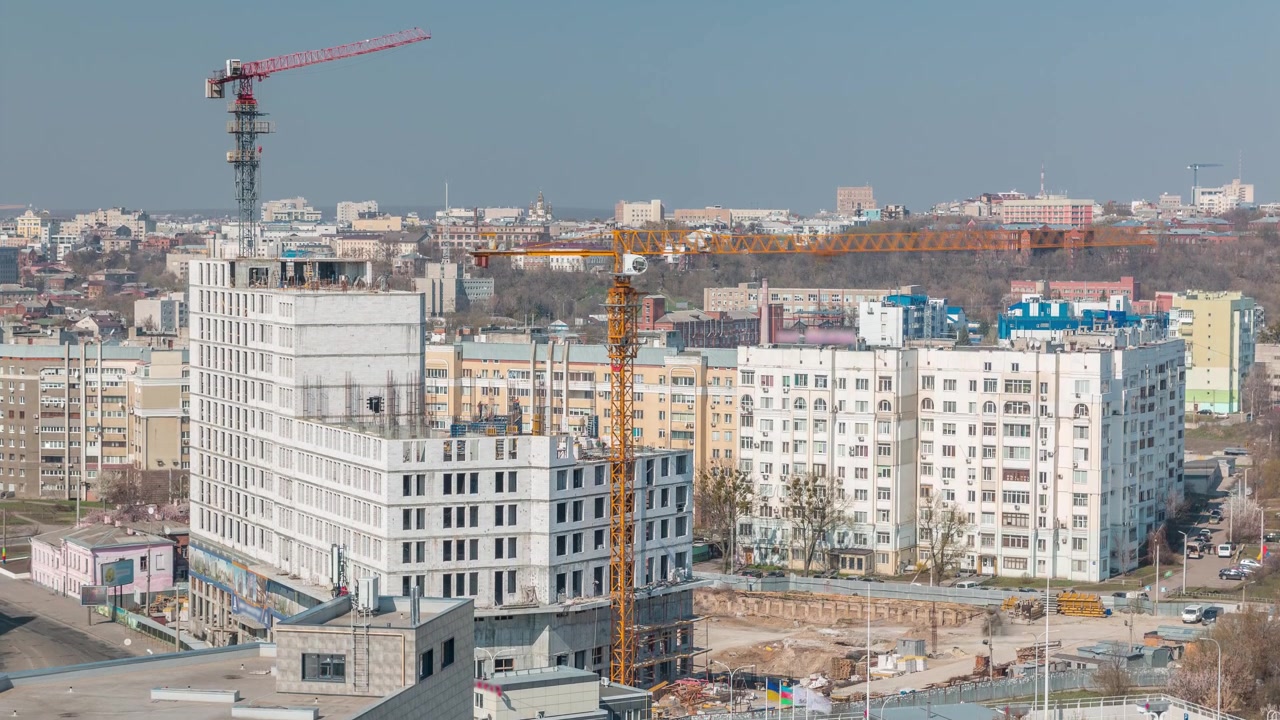 Cantiere con molte gru gialle accanto alla strada, timelapse, veduta aerea. Costruzione di un nuovo complesso residenziale a Kharkov, Ucraina.