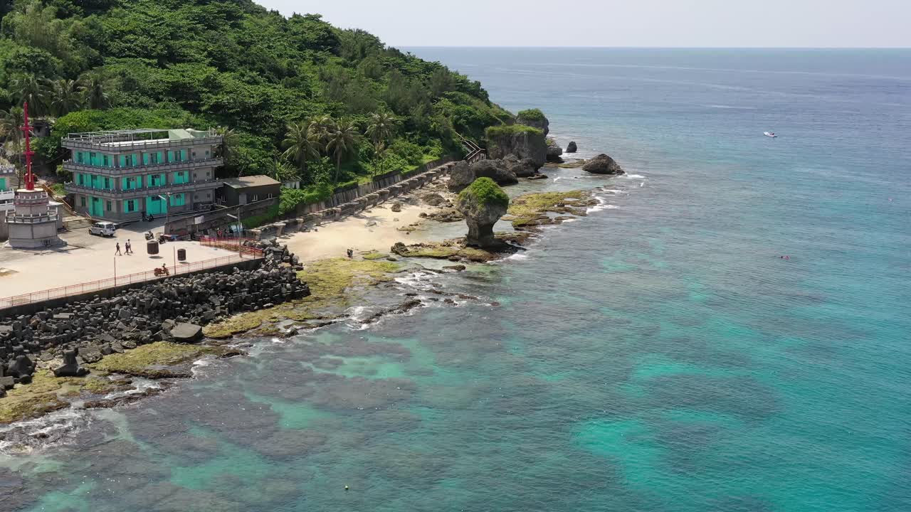 cinemática plataforma rodante aérea en toma que captura el prístino paisaje marino turquesa y el hito más destacado de liuqiu, florero de roca de arrecife de coral durante el día, condado de pingtung, taiwán, asia
