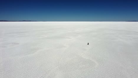 Vista-De-ángulo-Alto:-Moto-Y-Jinete-En-El-Vasto-Salar-De-Uyuni-En-Bolivia