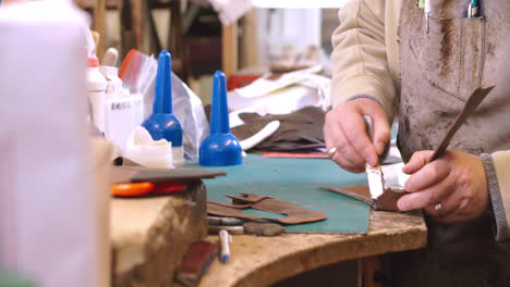 bespoke shoemaker glueing together leather pieces for shoe