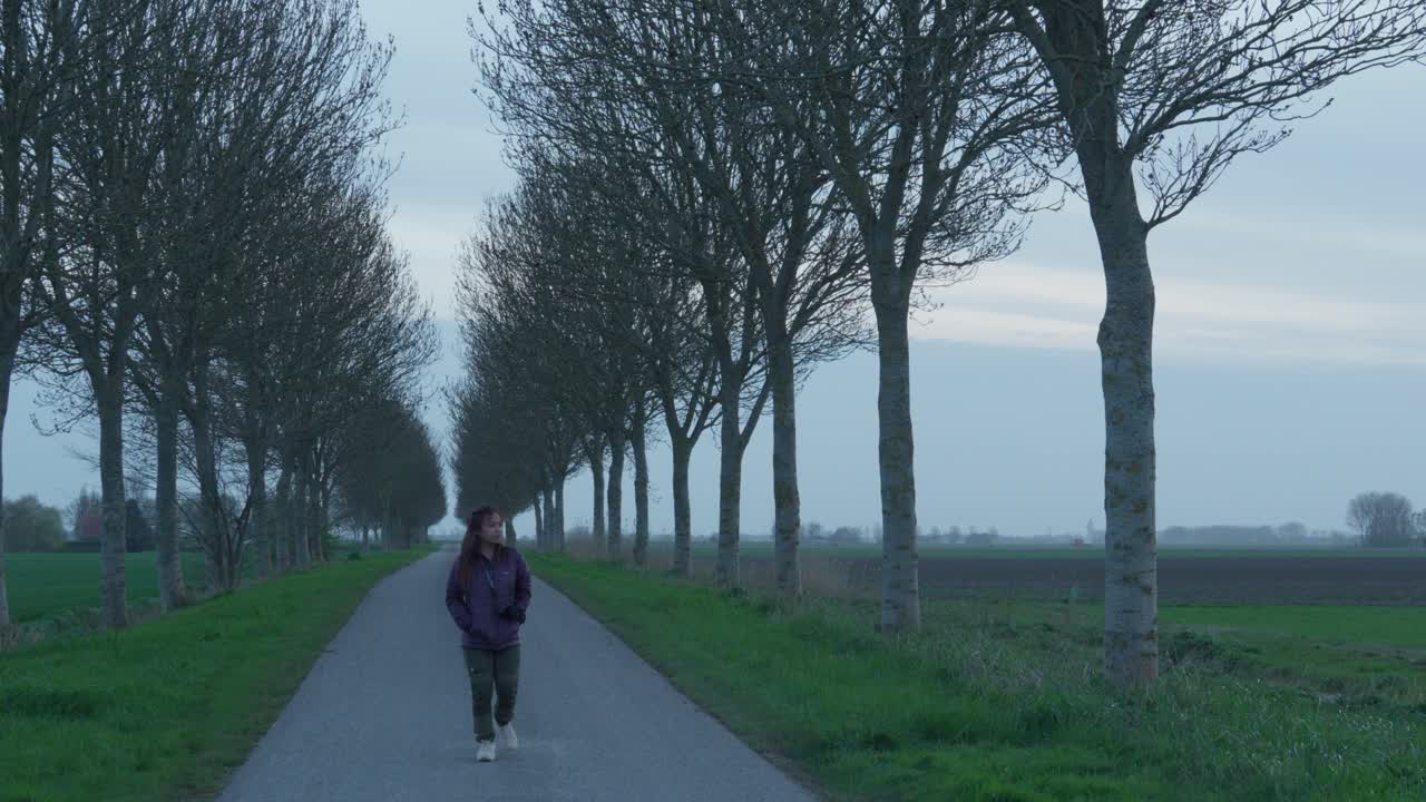 Beautiful young Indonesian visiting the Dutch countryside in autumn, idyllic alley