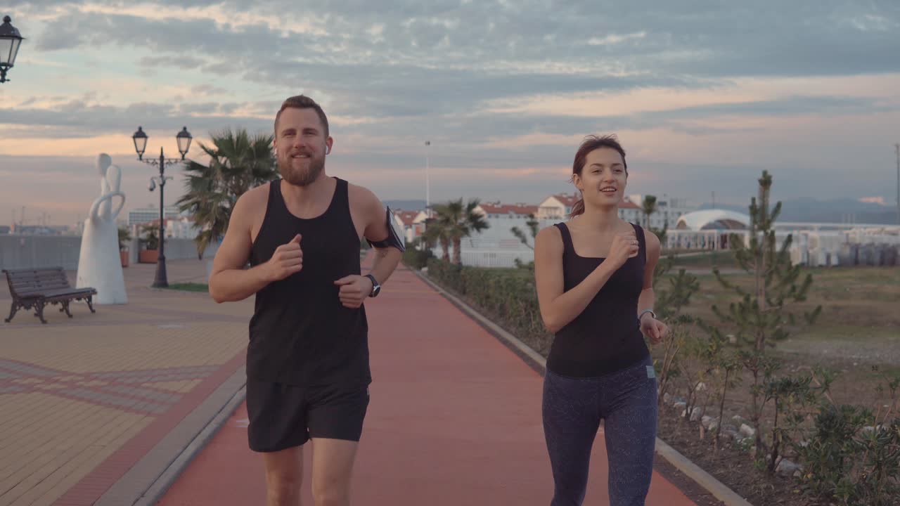 pareja corriendo juntos por un camino costero