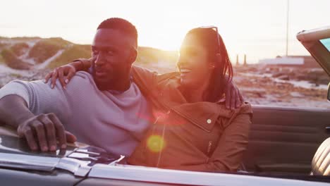 Pareja-Afroamericana-Abrazándose-Mientras-Están-Sentados-En-El-Auto-Convertible-En-La-Carretera