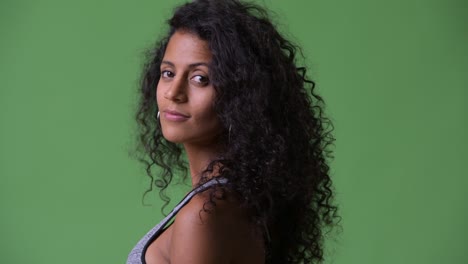 young beautiful hispanic woman with gym clothes looking back