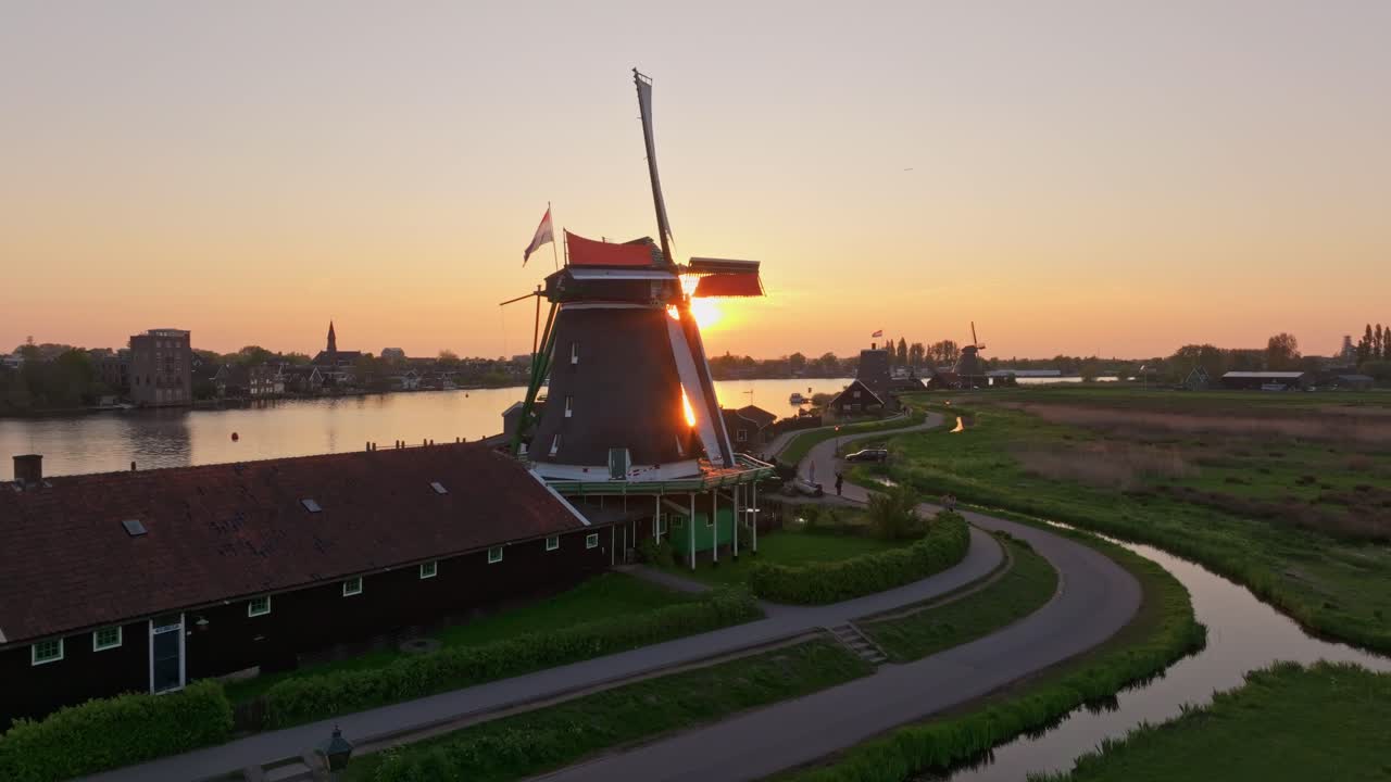 Vista aerea di mulini a vento storici in movimento sotto un cielo al tramonto, Zaanse Schans.